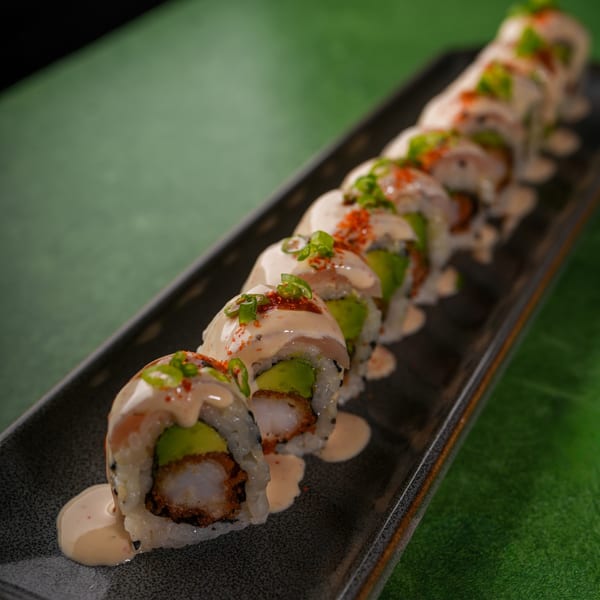 Mikhuna Japanese-Peruvian Cuisine's sushi rolls with avocado, shrimp tempura, creamy sauce, and green onions.