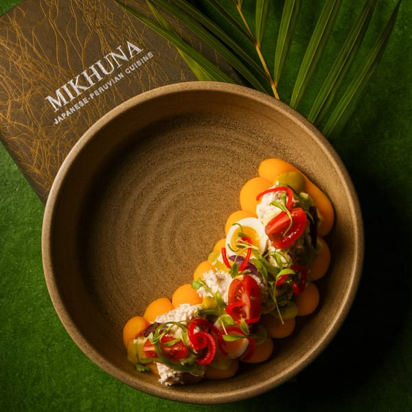 Mikhuna Japanese-Peruvian Cuisine's dish with melon, avocado, egg, tomatoes, and red peppers in a bowl.
