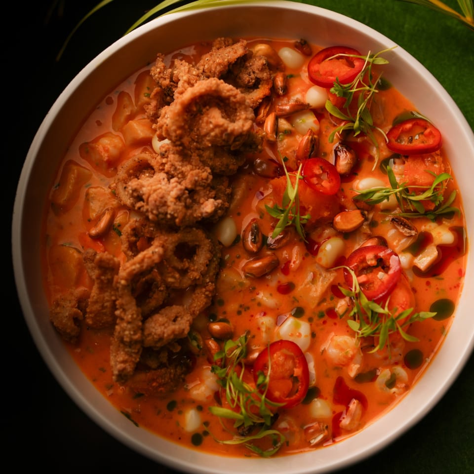 Mikhuna Japanese-Peruvian Cuisine's seafood dish with fried calamari, red peppers, and microgreens.